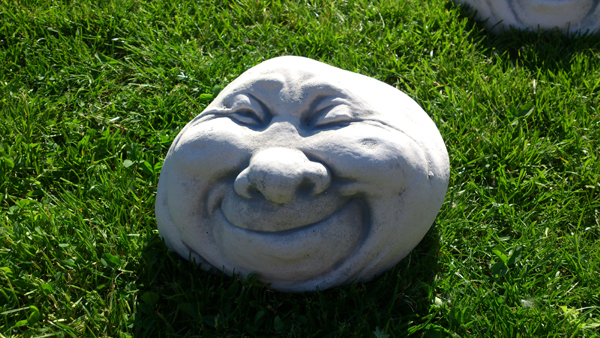 Garden decoration stone head "winking face"